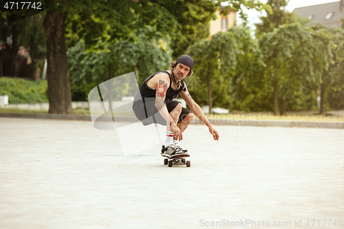 Image of Skateboarder doing a trick at the city\'s street in cloudly day