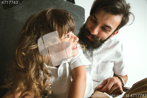 Image of Father playing with young son in their sitting room