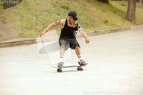 Image of Skateboarder doing a trick at the city\'s street in cloudly day