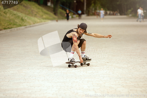 Image of Skateboarder doing a trick at the city\'s street in cloudly day