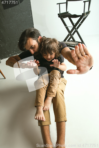 Image of Father playing with young son in their sitting room