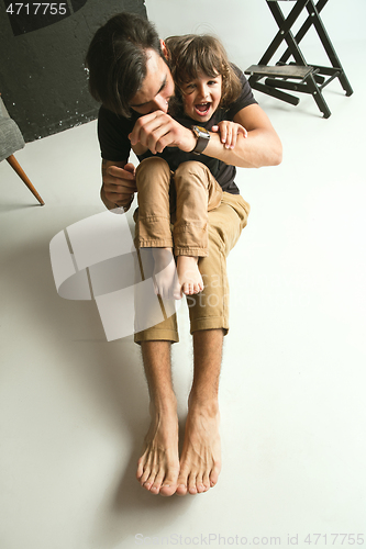 Image of Father playing with young son in their sitting room