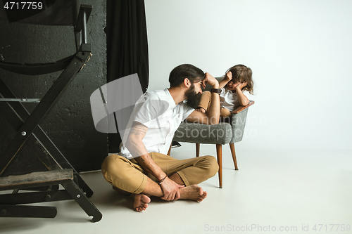 Image of Father playing with young son in their sitting room