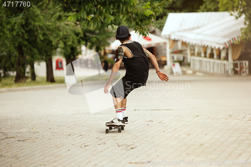 Image of Skateboarder doing a trick at the city\'s street in cloudly day