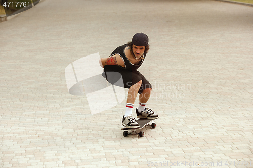 Image of Skateboarder doing a trick at the city\'s street in cloudly day