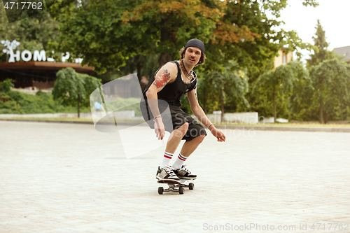 Image of Skateboarder doing a trick at the city\'s street in cloudly day