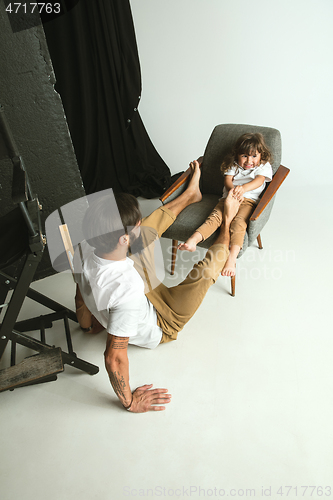 Image of Father playing with young son in their sitting room