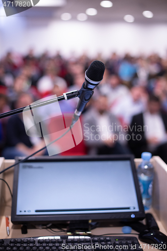 Image of laptop computer and microphone at podium