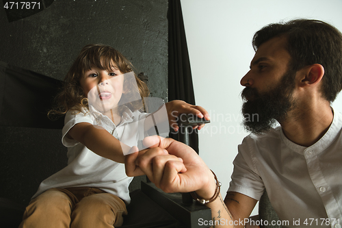 Image of Father playing with young son in their sitting room