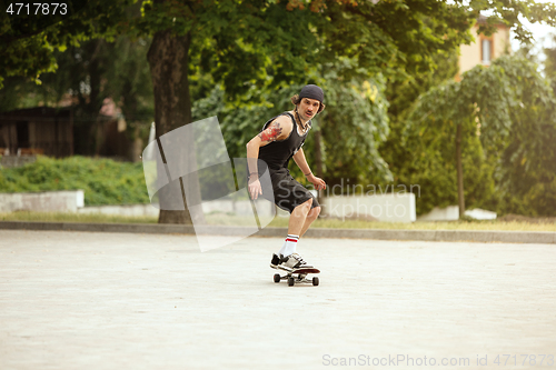 Image of Skateboarder doing a trick at the city\'s street in cloudly day