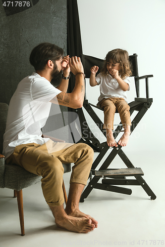 Image of Father playing with young son in their sitting room