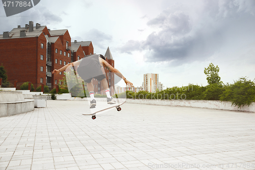 Image of Skateboarder doing a trick at the city\'s street in cloudly day