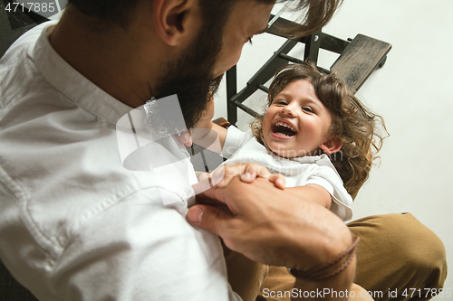 Image of Father playing with young son in their sitting room