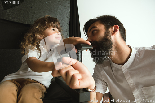 Image of Father playing with young son in their sitting room