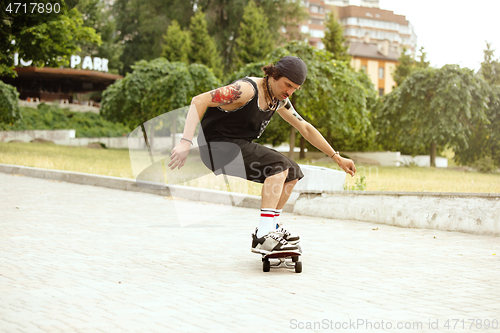 Image of Skateboarder doing a trick at the city\'s street in cloudly day