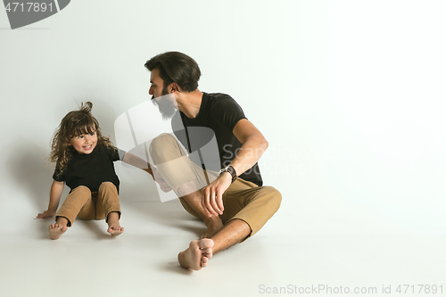 Image of Father playing with young son against white studio background