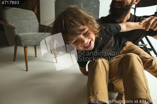 Image of Father playing with young son in their sitting room