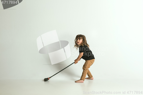 Image of Little child sitting and playing in armchair on white studio background