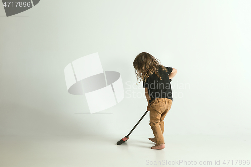 Image of Little child sitting and playing in armchair on white studio background