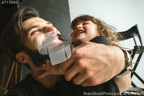 Image of Father playing with young son in their sitting room