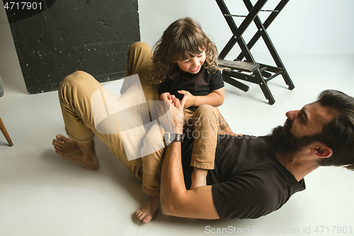 Image of Father playing with young son in their sitting room