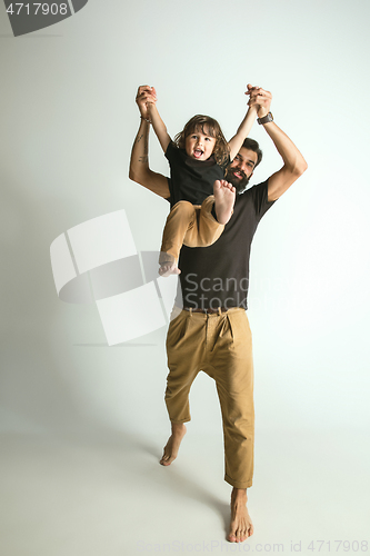 Image of Father playing with young son against white studio background