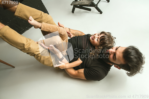 Image of Father playing with young son in their sitting room