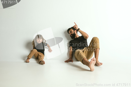 Image of Father playing with young son against white studio background