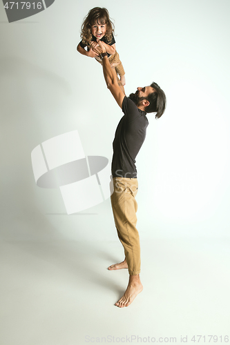 Image of Father playing with young son against white studio background