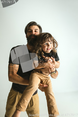 Image of Father playing with young son against white studio background