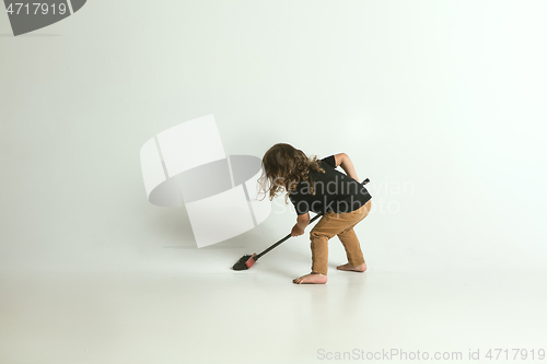 Image of Little child sitting and playing in armchair on white studio background