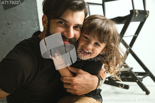Image of Father playing with young son in their sitting room