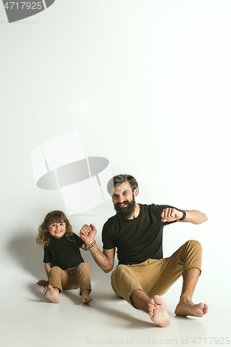 Image of Father playing with young son against white studio background