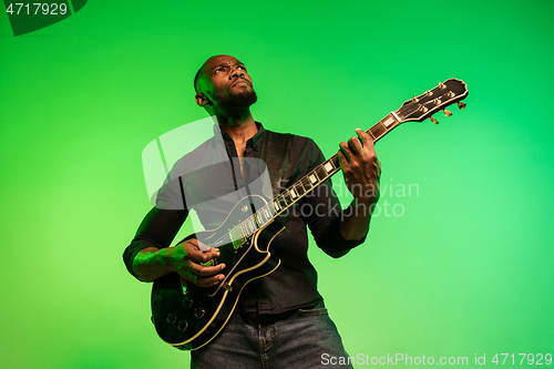 Image of Young african-american jazz musician playing the guitar