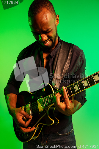 Image of Young african-american jazz musician playing the guitar