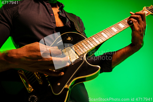 Image of Young african-american jazz musician playing the guitar