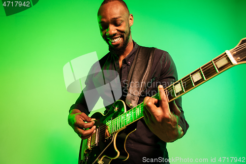 Image of Young african-american jazz musician playing the guitar