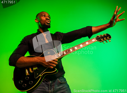 Image of Young african-american jazz musician playing the guitar