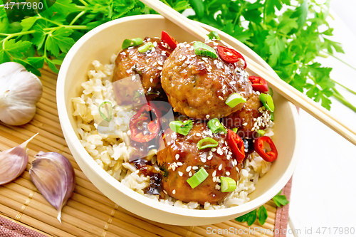 Image of Meatballs in sweet and sour sauce with rice on bamboo