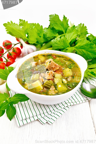 Image of Soup with pisto sauce in bowl on wooden board