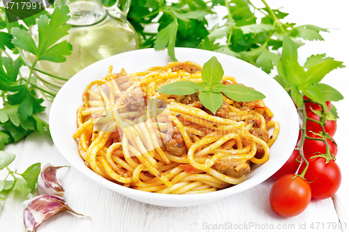 Image of Spaghetti with bolognese in plate on light wooden board