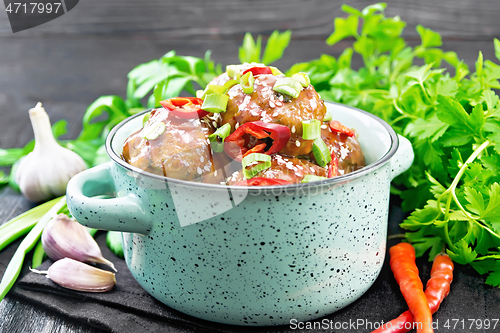 Image of Meatballs in sweet and sour sauce on dark board