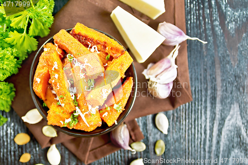 Image of Pumpkin fried with spices in bowl on dark board top