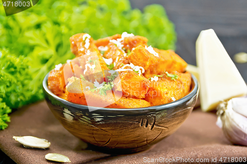 Image of Pumpkin fried with spices in bowl on board