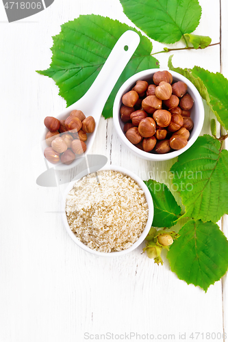 Image of Flour and hazelnuts in bowls on light board top