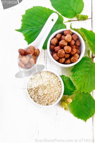 Image of Flour and hazelnuts in bowls on light board top