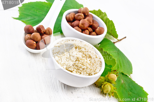 Image of Flour and hazelnuts in bowls on board