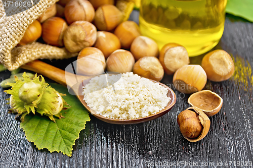 Image of Flour in spoon with nuts on board