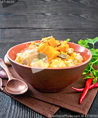 Image of Porridge millet with spicy pumpkin in clay bowl on towel