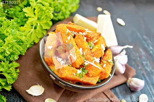 Image of Pumpkin fried with spices in bowl on black board